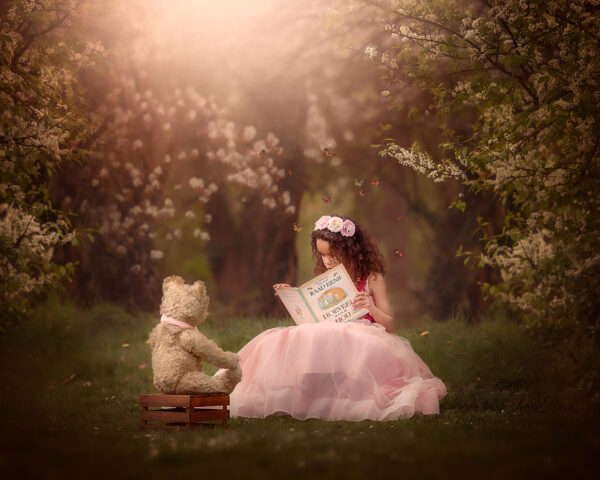 Canon EOS r5 lente portret van een meisje die een boek voorleest aan een teddybeer in het bos bij de bloesem door natuurlijk licht fotograaf Willie Kers uit Apeldoorn copy