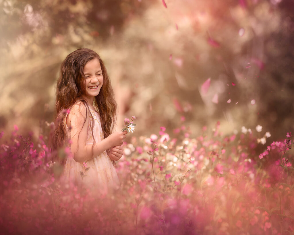 online opleiding portret fotografie of a happy little girl standing in a field of pink flowers by dutch natural light photographer Willie Kers copy