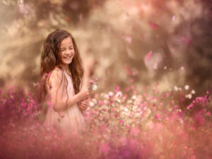 online opleiding portret fotografie of a happy little girl standing in a field of pink flowers by dutch natural light photographer Willie Kers copy