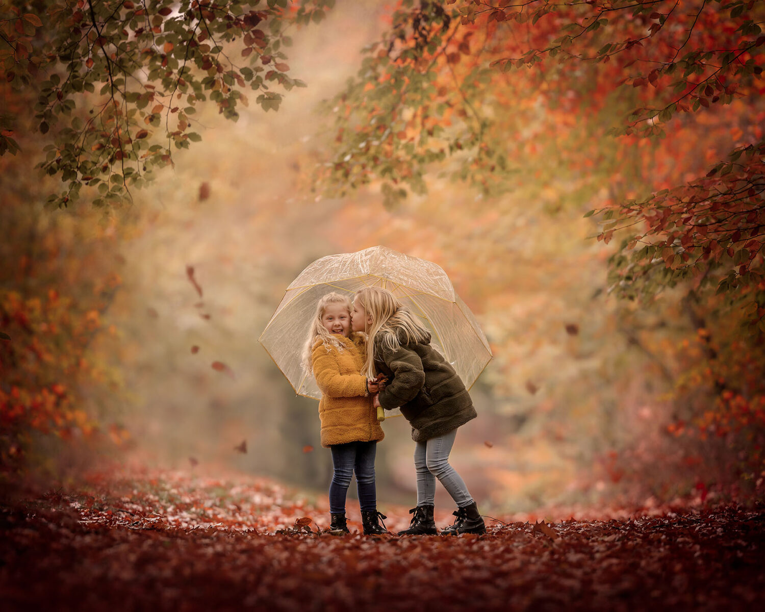 Fine art herfstportret van twee kinderen met een paraplu in het bos door fotograaf Willie Kers