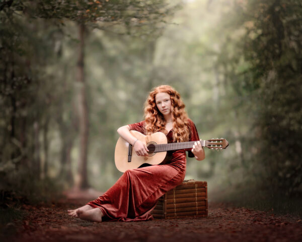 fine art portret van een roodharige meisje met krullen en een gitaar in een herfstbos door natuurlijk licht fotograaf willie Kers uit apeldoorn